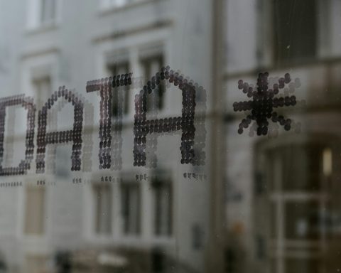 a close up of a window with a building in the background