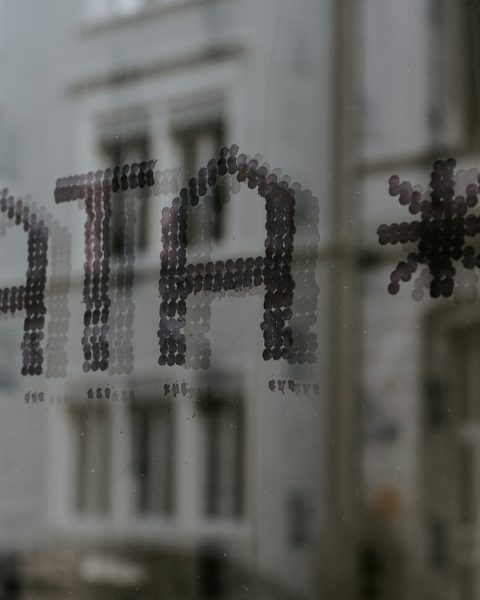 a close up of a window with a building in the background