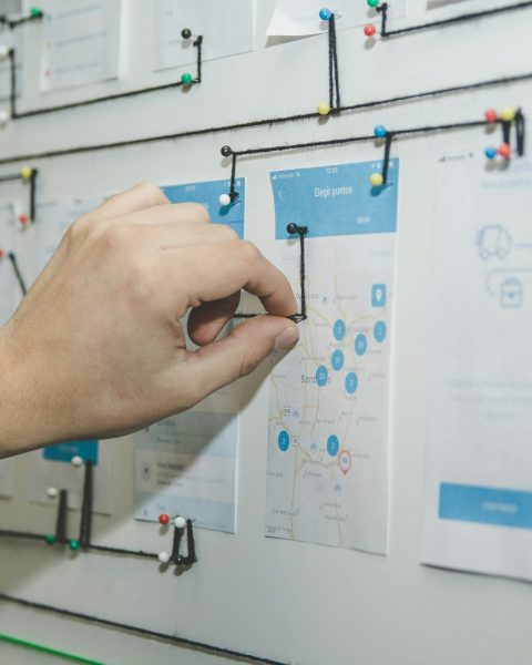 person working on blue and white paper on board