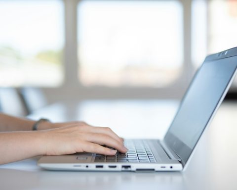 a close up of a person typing on a laptop
