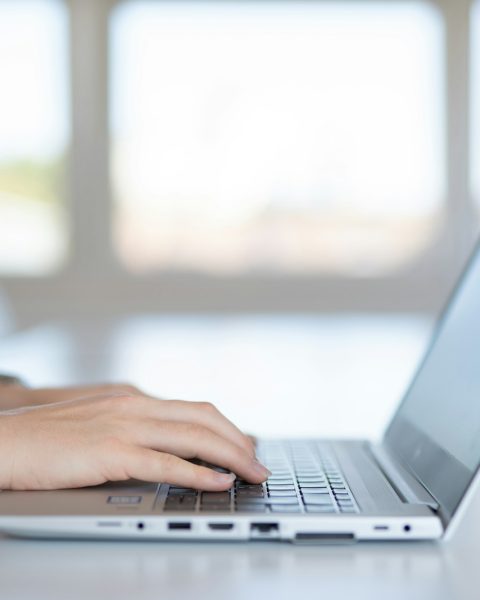 a close up of a person typing on a laptop