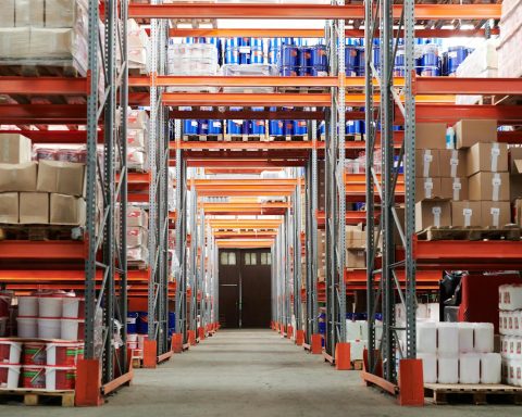 Wide angle view of a warehouse with stocked shelves and boxes.