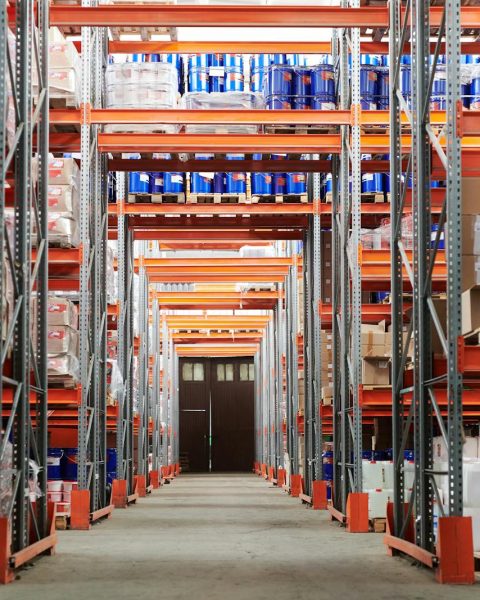 Wide angle view of a warehouse with stocked shelves and boxes.