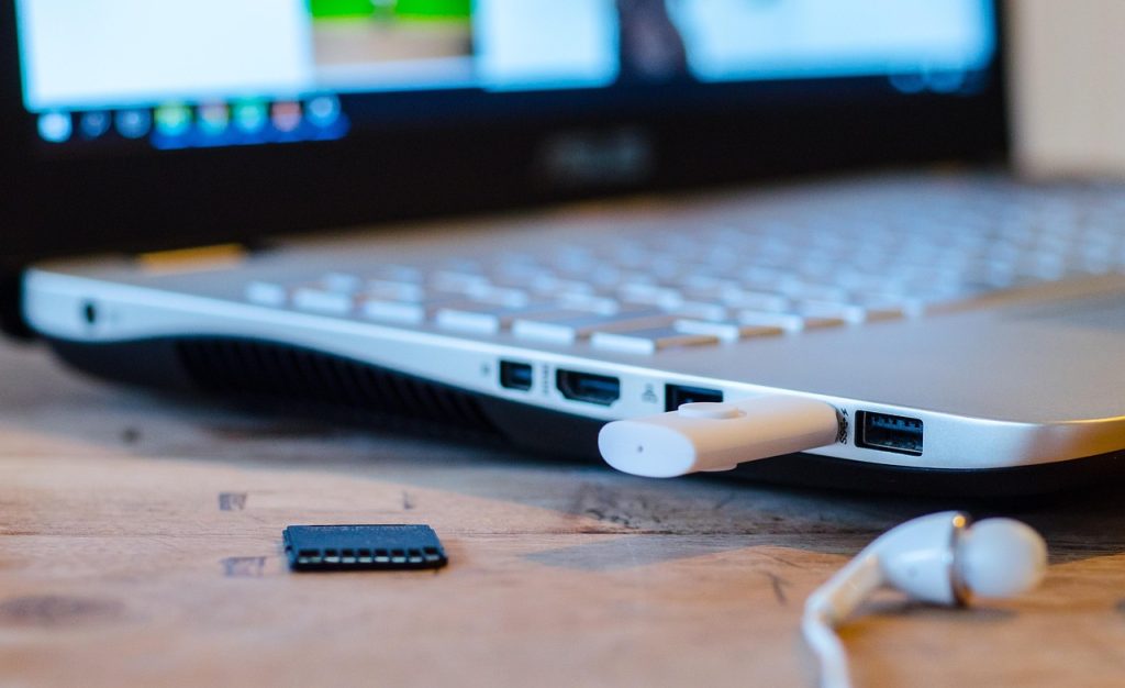 Draadloze koptelefoon liggend op een bureau naast een laptop