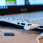 Draadloze koptelefoon liggend op een bureau naast een laptop
