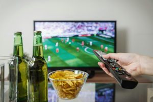 Persoon ontspannen op de bank kijkt naar een streamingdienst op televisie
