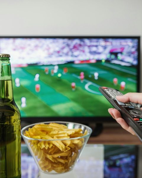 Persoon ontspannen op de bank kijkt naar een streamingdienst op televisie