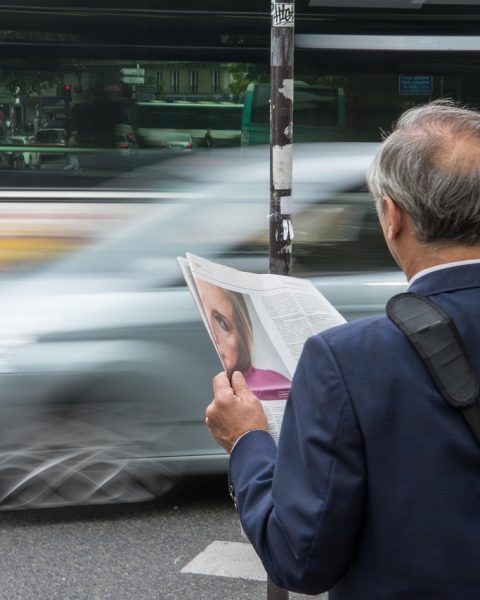Persoon die zowel een papieren krant als een tablet vasthoudt, als symbool voor de overgang van analoge naar digitale media