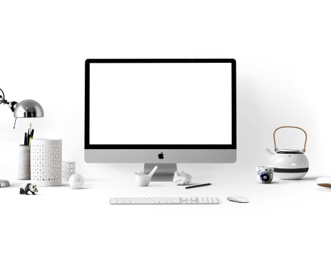 Medewerker aan bureau met meerdere schermen vol open applicaties, zichtbaar overweldigd