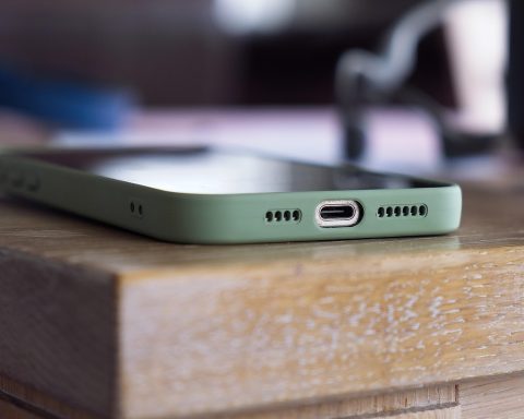 Iemand inspecteert een refurbished smartphone op zichtbare schade