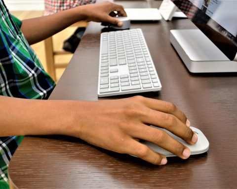 Een student die op een laptop spelletjes speelt in een schoolomgeving