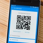 Ondernemer scant een barcode in een magazijn met zijn smartphone