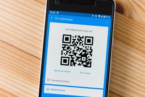 Ondernemer scant een barcode in een magazijn met zijn smartphone