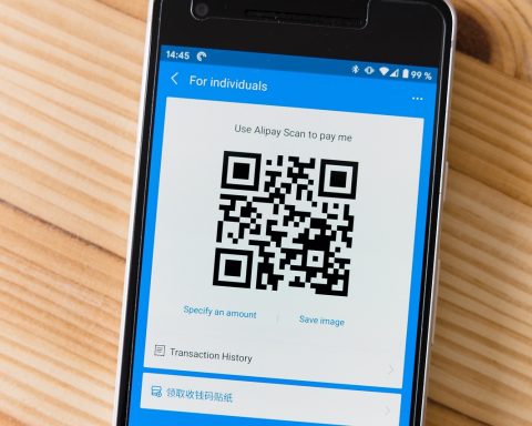Ondernemer scant een barcode in een magazijn met zijn smartphone