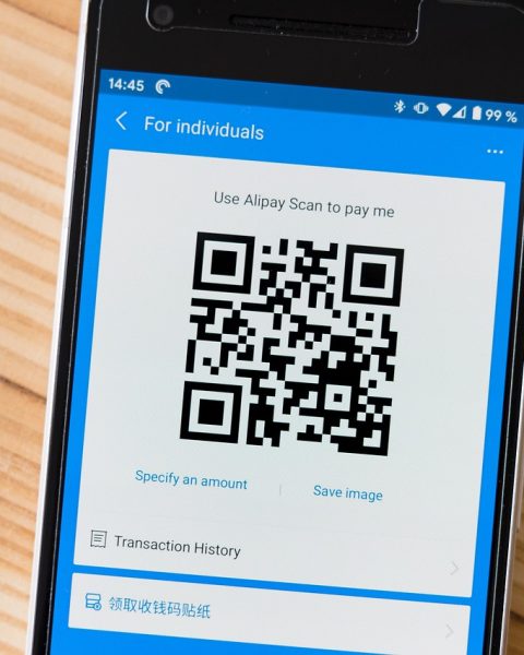 Ondernemer scant een barcode in een magazijn met zijn smartphone