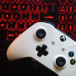 Een gaming controller naast een laptop met een gamescherm, symbool voor legaal en betaalbaar gamen