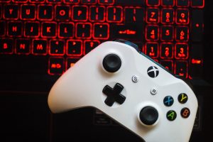 Een gaming controller naast een laptop met een gamescherm, symbool voor legaal en betaalbaar gamen