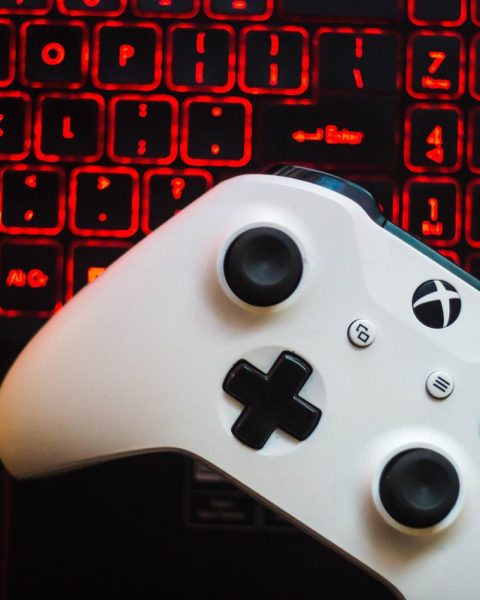 Een gaming controller naast een laptop met een gamescherm, symbool voor legaal en betaalbaar gamen