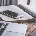 Een laptop en smartphone naast elkaar op een bureau, symbool voor het schakelen tussen Windows en Android