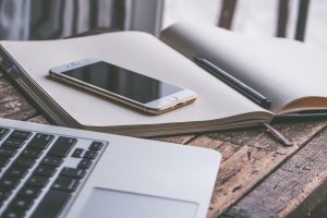 Een laptop en smartphone naast elkaar op een bureau, symbool voor het schakelen tussen Windows en Android