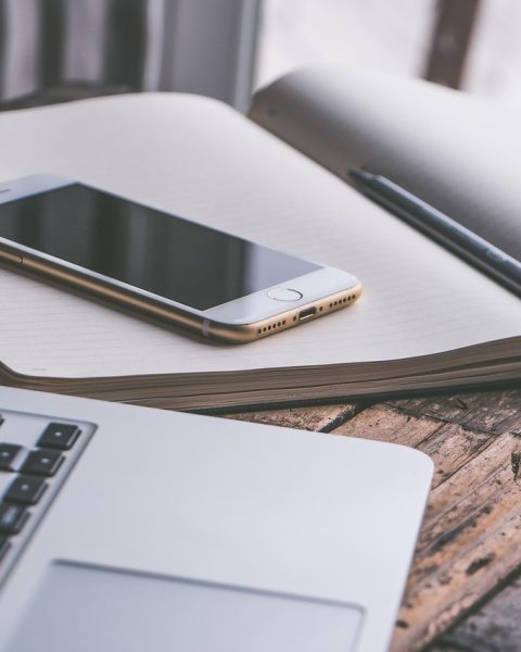 Een laptop en smartphone naast elkaar op een bureau, symbool voor het schakelen tussen Windows en Android