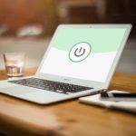 Persoon die werkt aan een laptop op een thuiskantoor met beveiligingsinstellingen open op het scherm