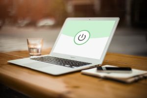 Persoon die werkt aan een laptop op een thuiskantoor met beveiligingsinstellingen open op het scherm