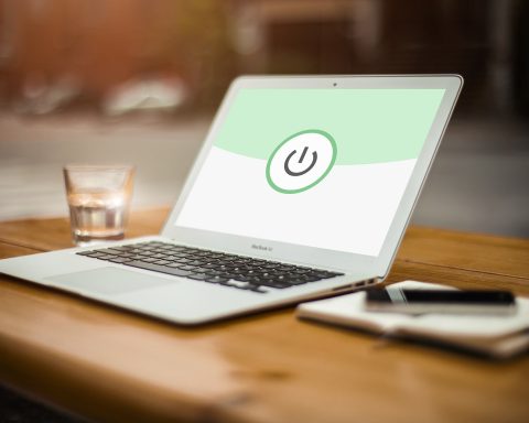Persoon die werkt aan een laptop op een thuiskantoor met beveiligingsinstellingen open op het scherm