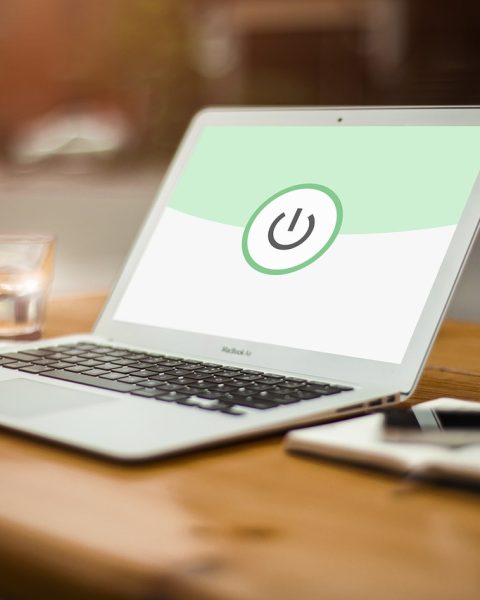 Persoon die werkt aan een laptop op een thuiskantoor met beveiligingsinstellingen open op het scherm