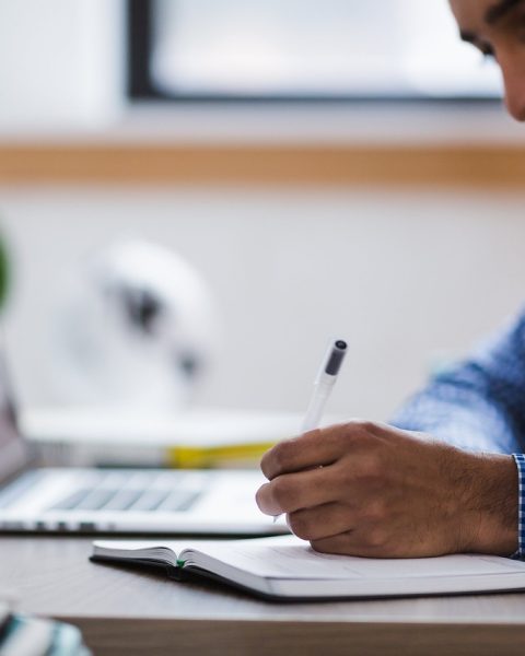 Persoon die aan een laptop cybersecurity aan het studeren is